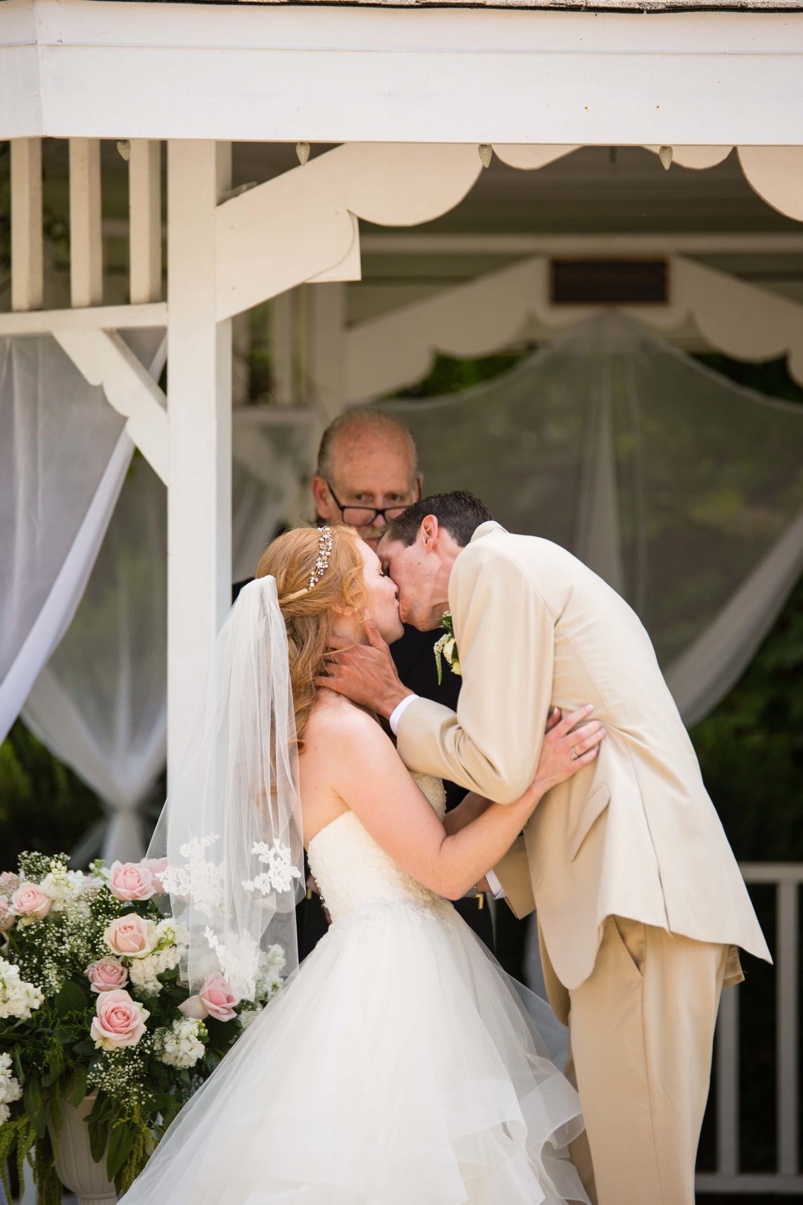 Bride and groom share their first kiss under the gazebo at Heritage House in Arroyo Grande
