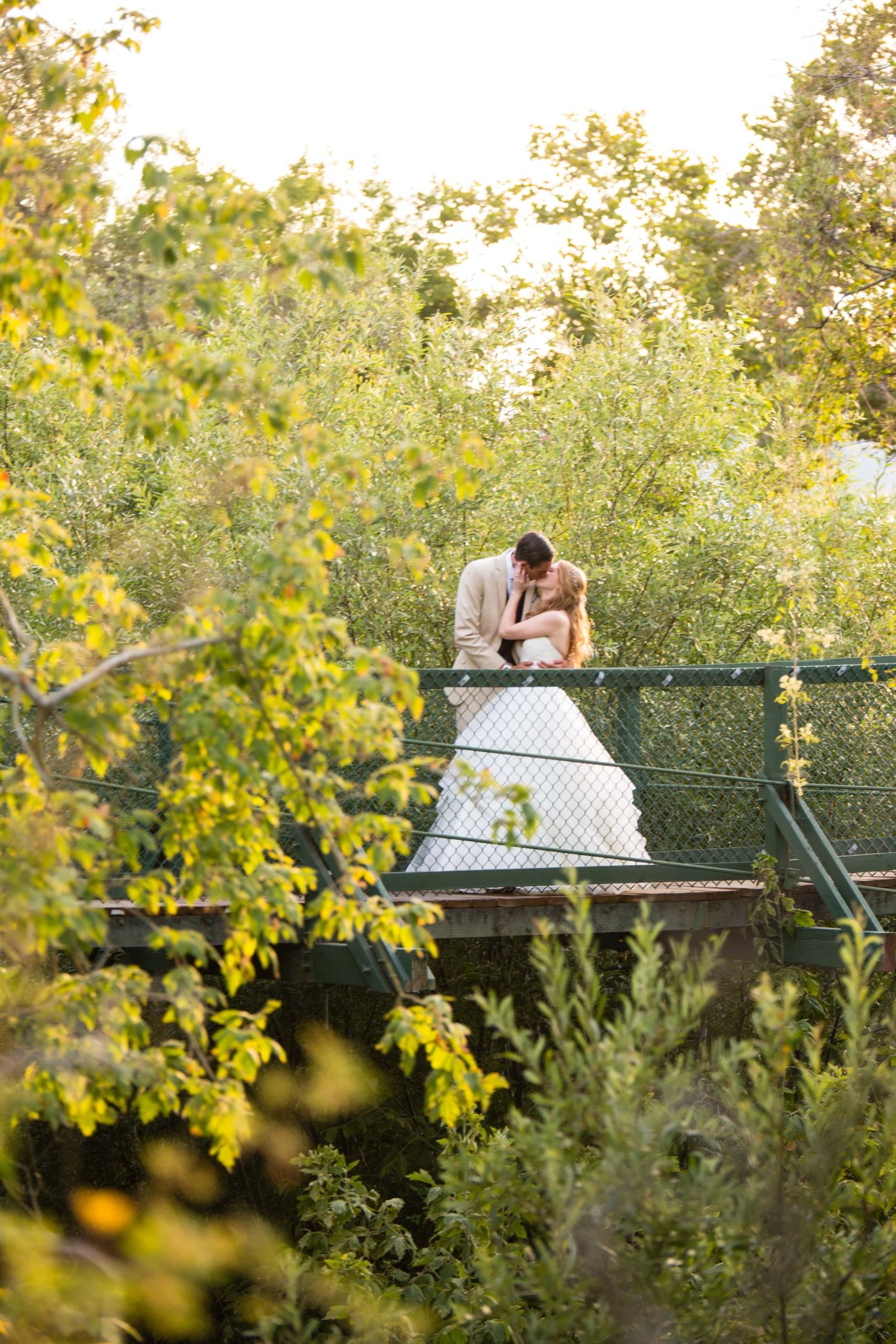 Bride and groom kiss on a bridge at Heritage House in Arroyo Grande