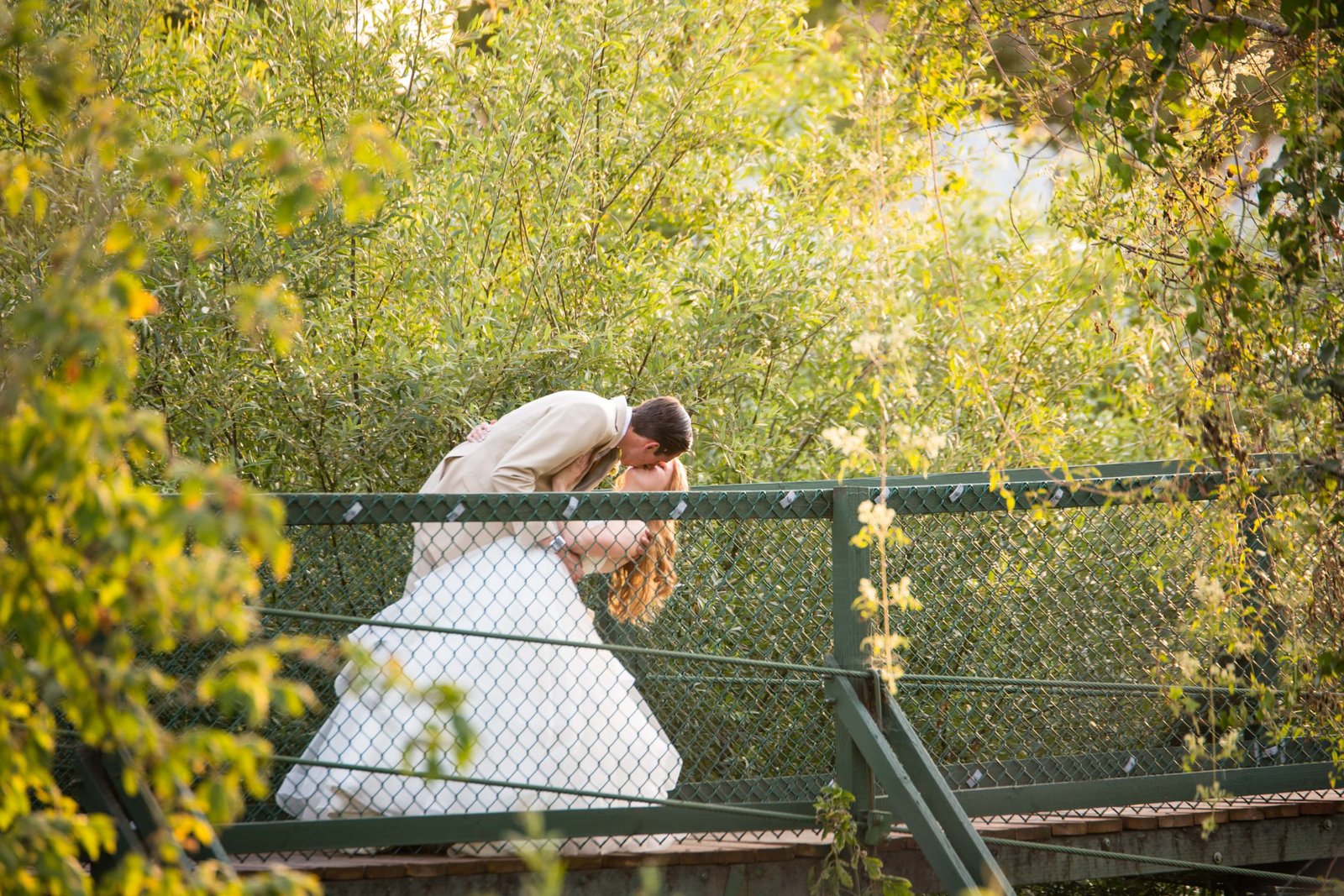 Groom dipping bride for a kiss on a bridge at Heritage House in Arroyo Grande