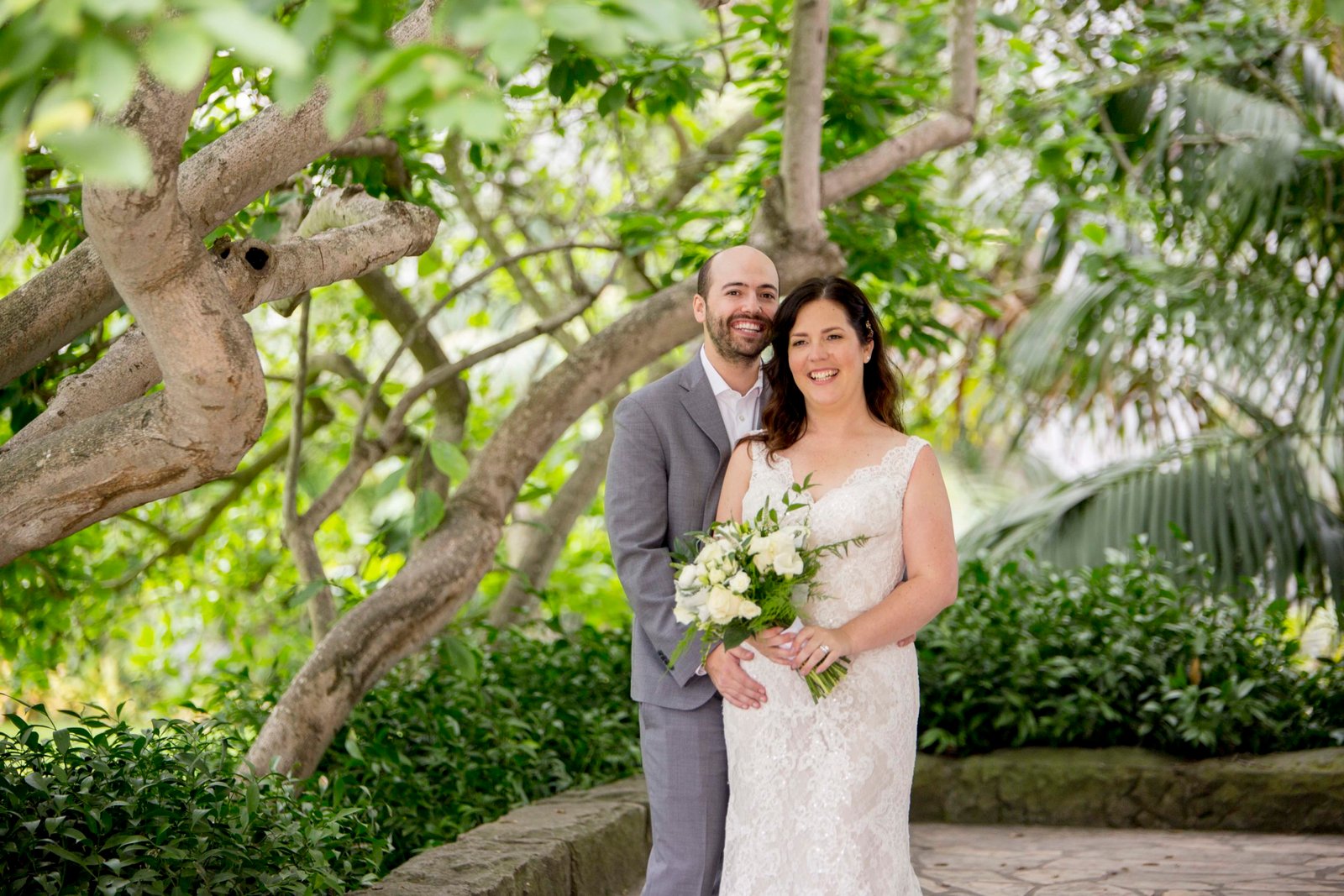 Bride and groom pose under a tree at the Santa Barbara Courthouse