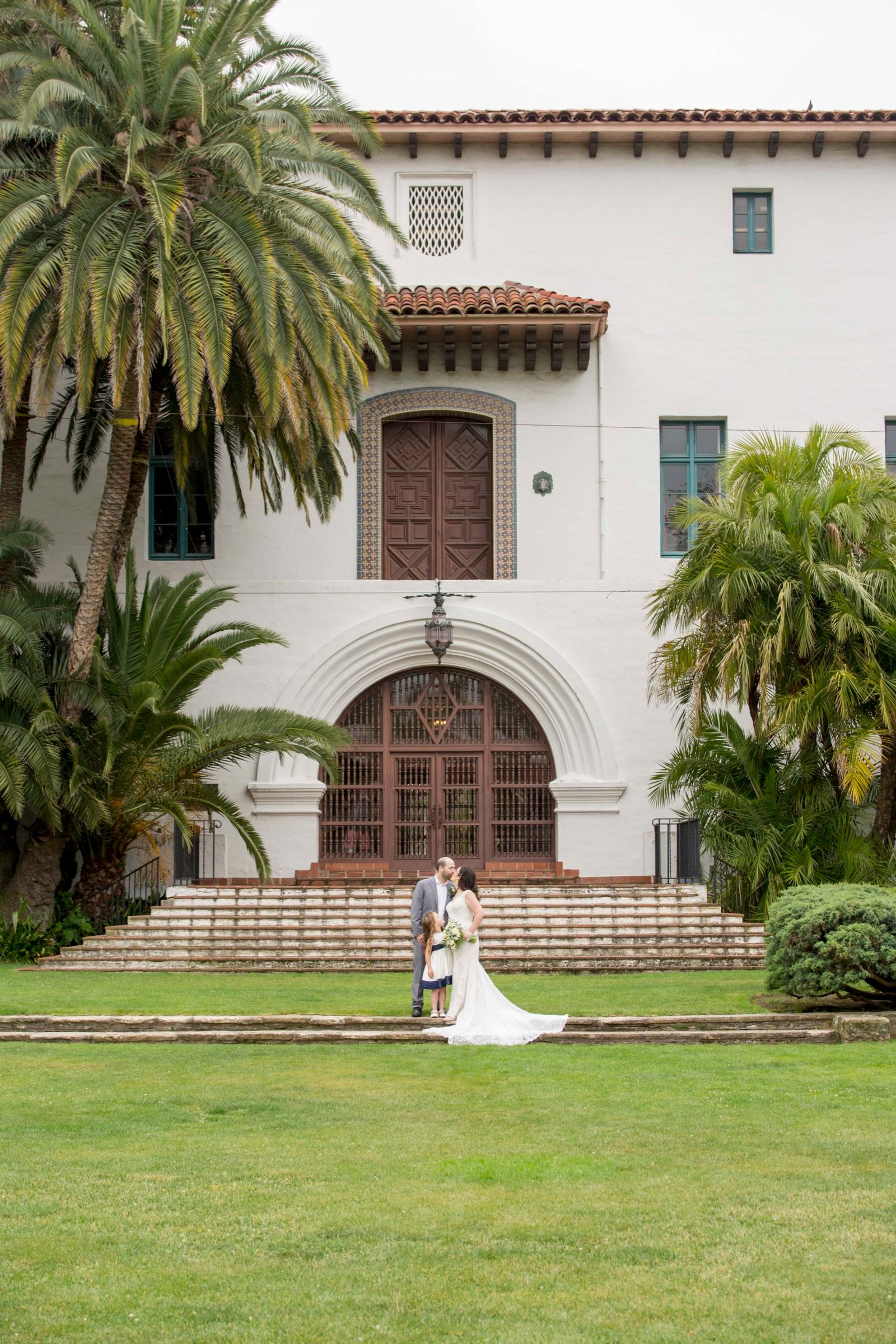 Bride and groom pose on the grass at the Santa Barbara Courthouse