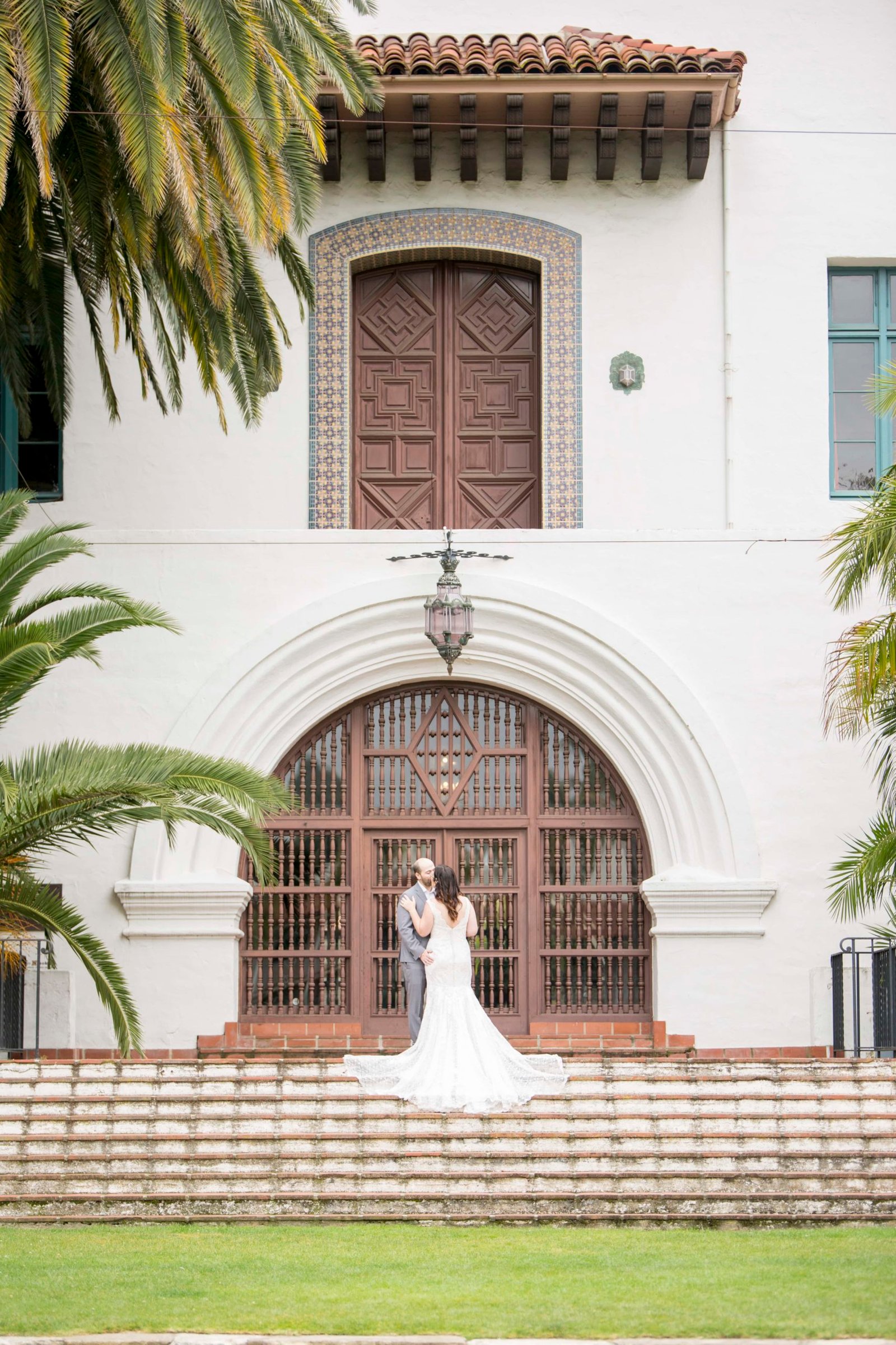 Bride and groom stand ont he steps at the Santa Barbara Courthouse