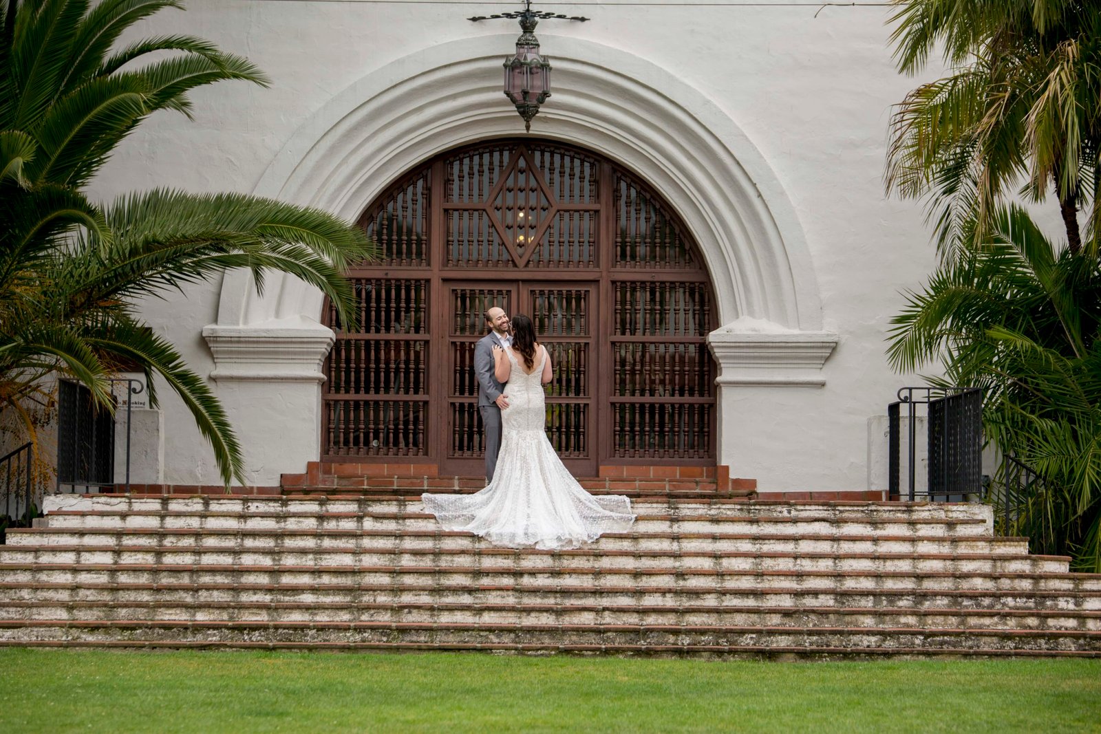 Bride and groom stand with the bride's dress cascading down the steps at the Santa Barbara Courthouse