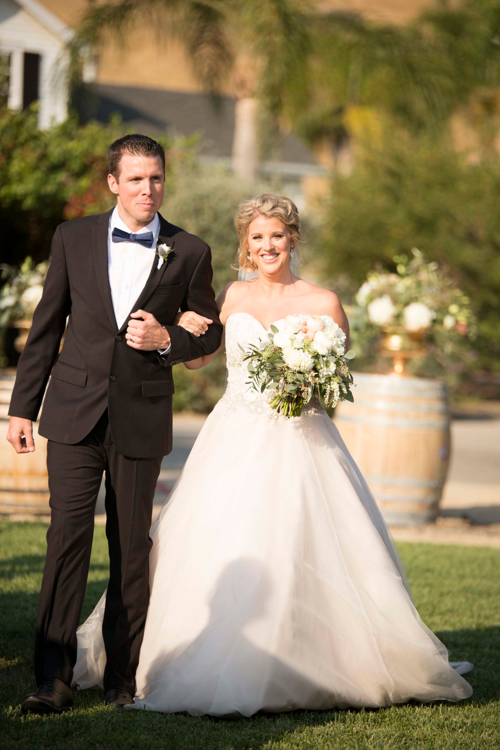 Bride walks done the aisle with her brother at Higuera Ranch