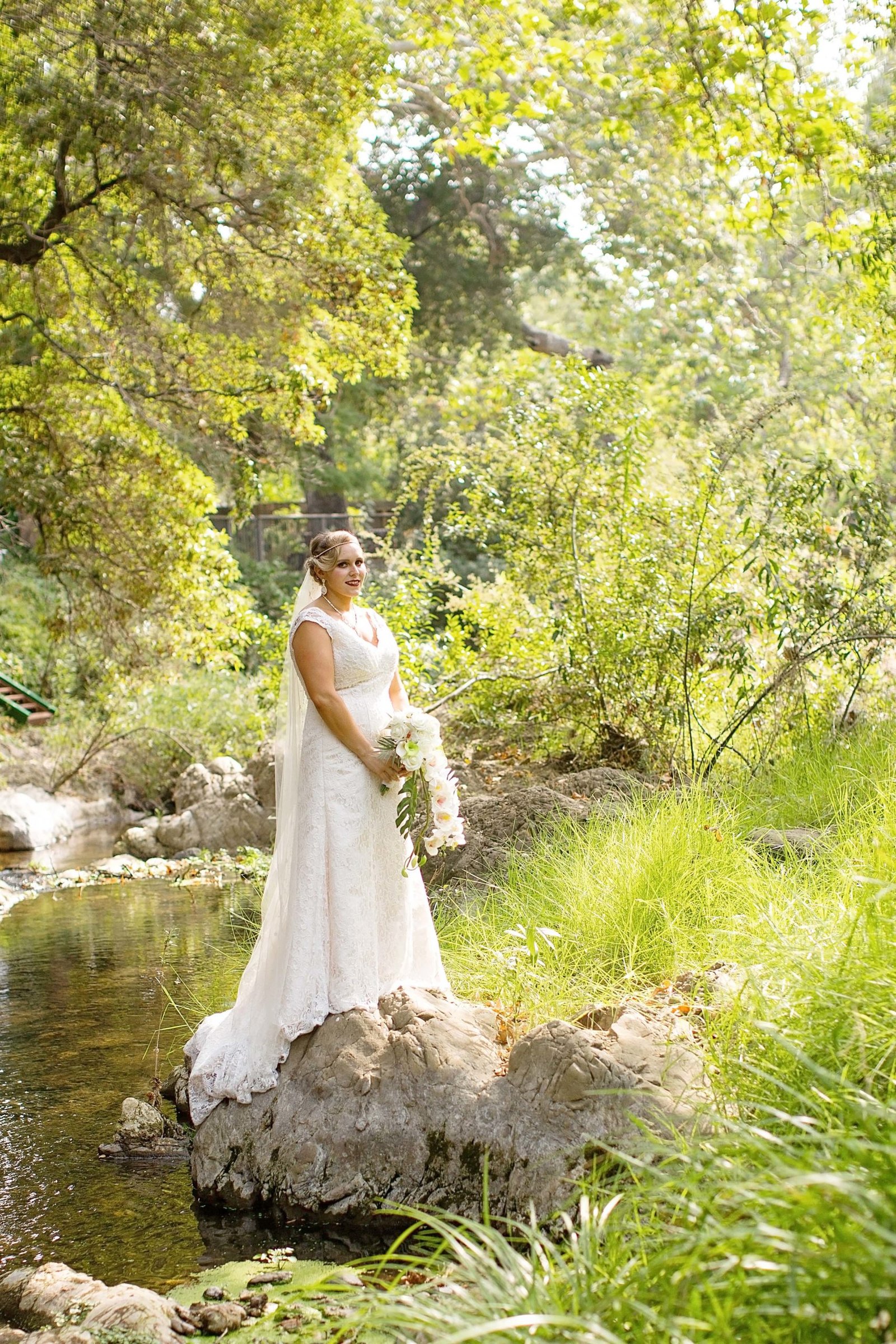 Bride standing on a rock in the creek at The Monday Club