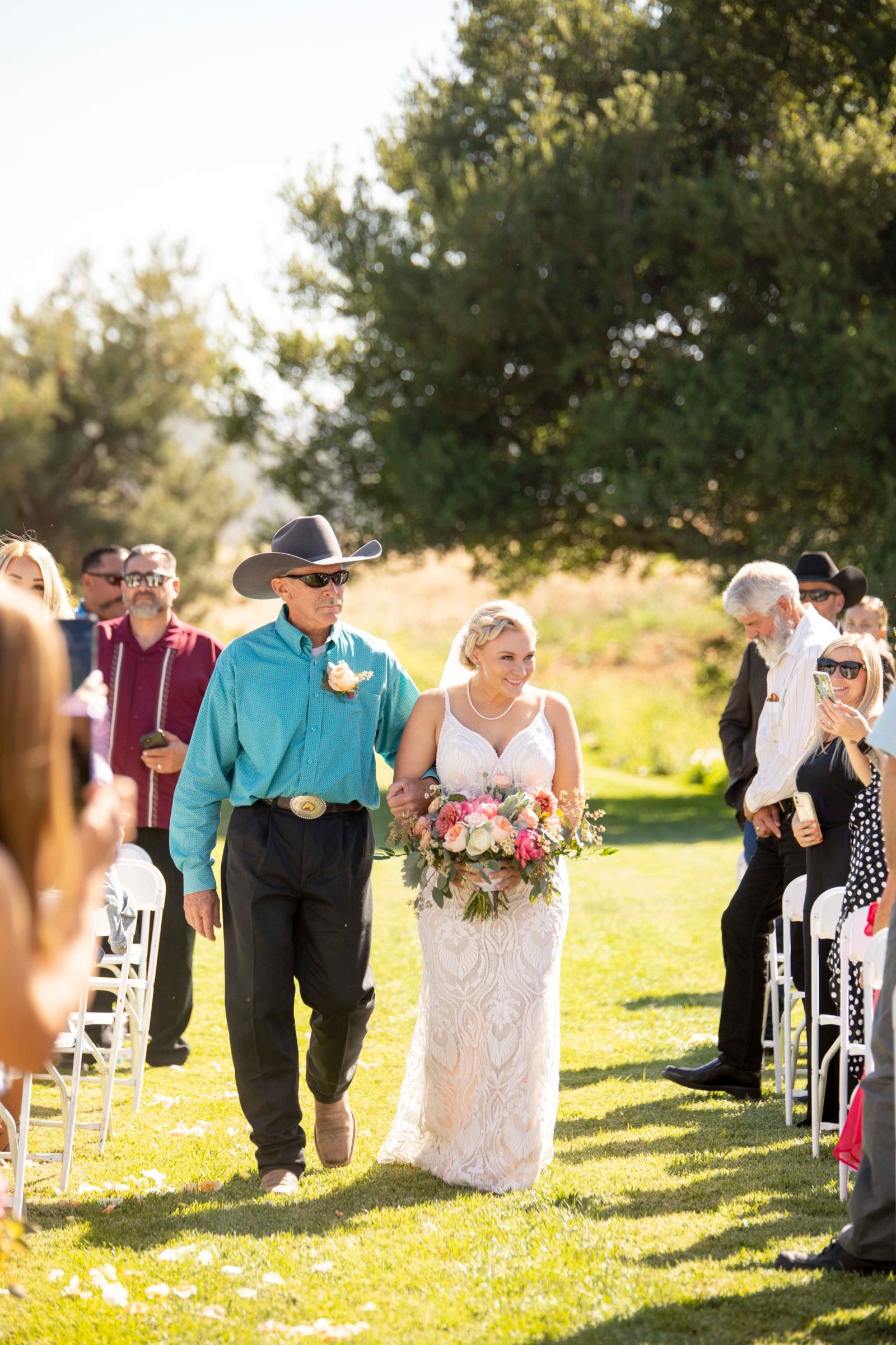 bride smiling as her dad walks her down the aisle at Loma Grande Ranch