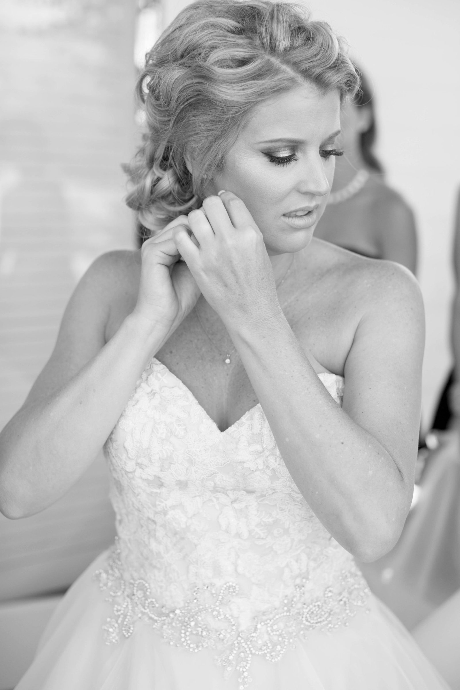 Bride putting n an earring before the wedding ceremony at Higuera Ranch