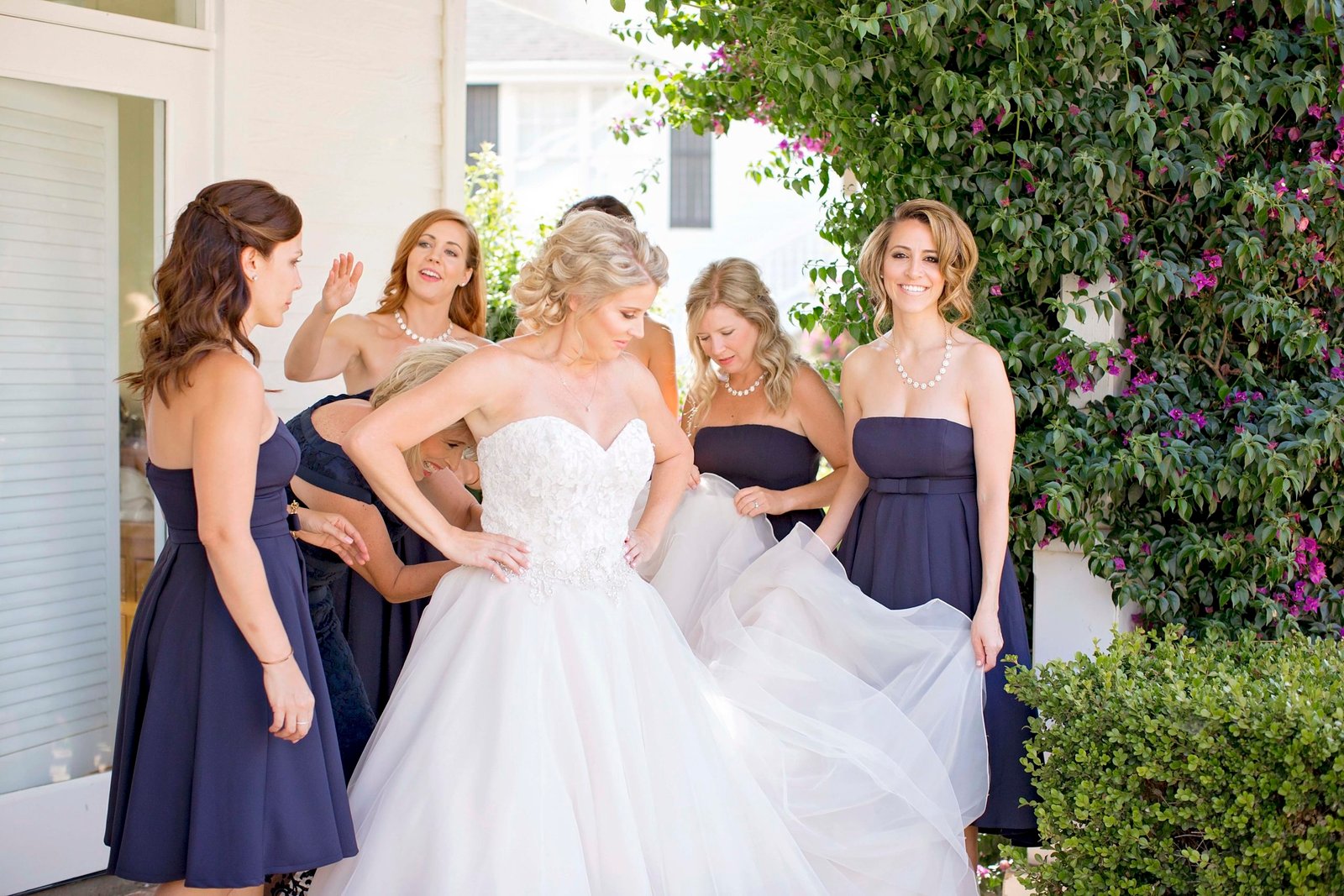 Bridesmaids help the bride get dressed at Higuera Ranch