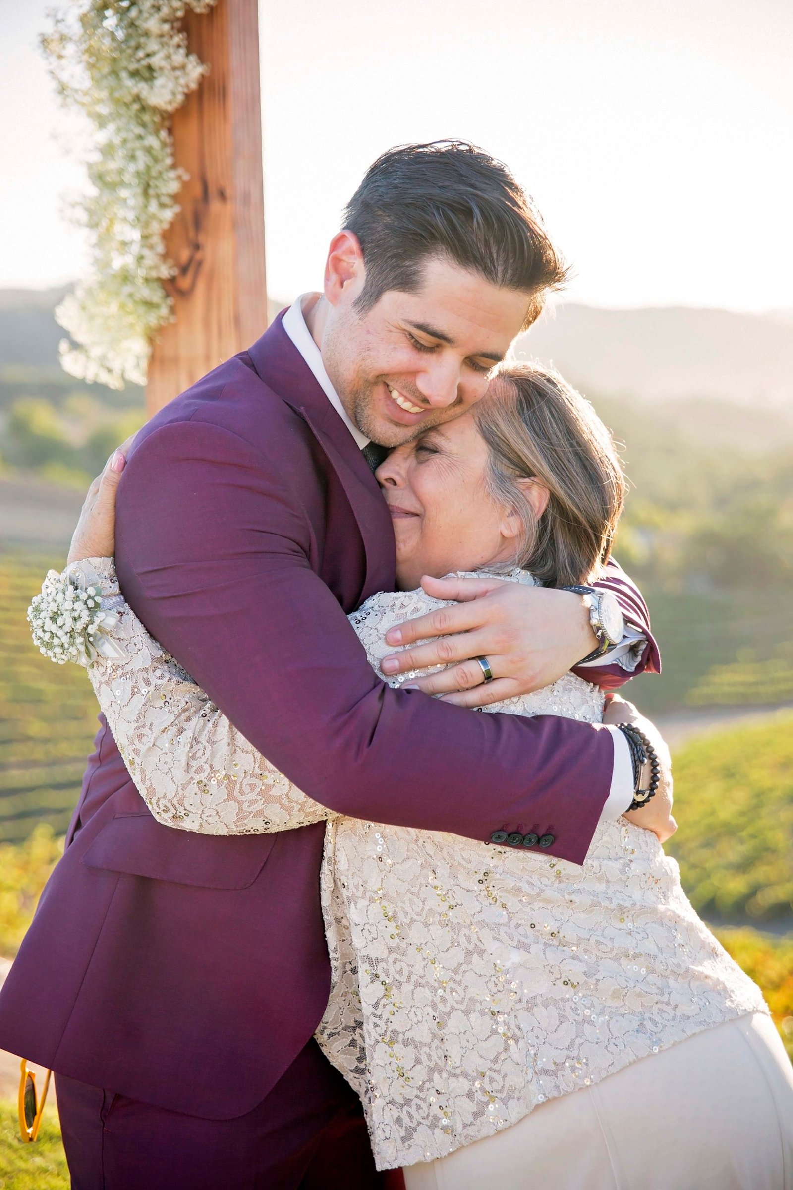 Groom hugging his mom while smiling