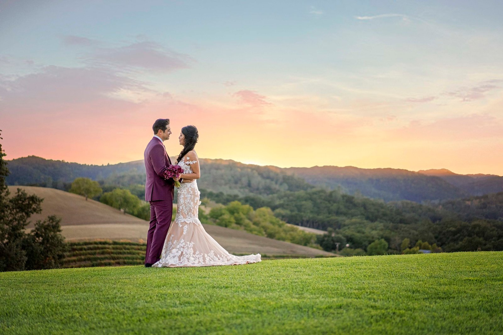 Bride and groom facing each other at sunset on the hill at Opolo