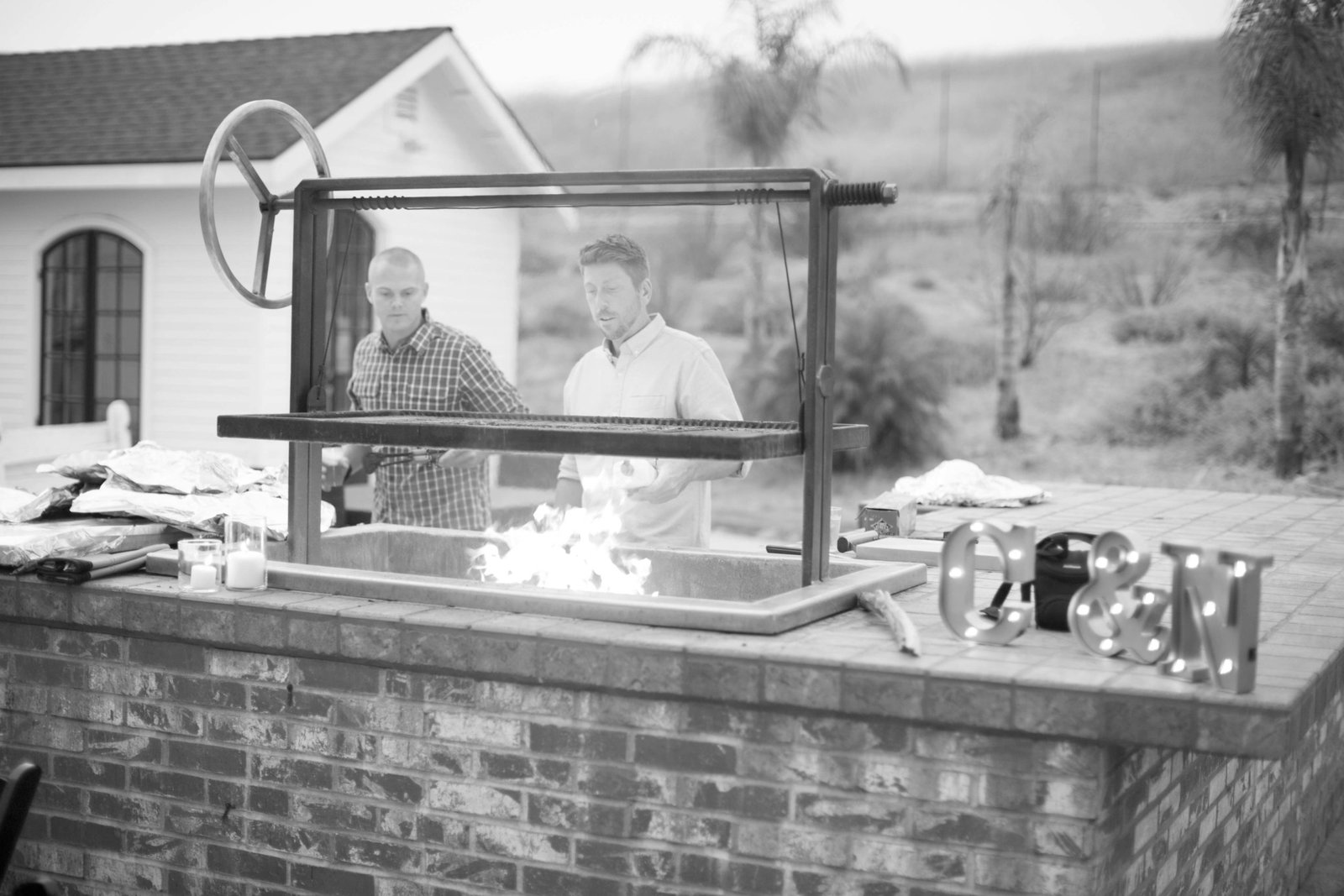 Black and white photo of a BBQ during the rehearsal dinner at Higuera Ranch