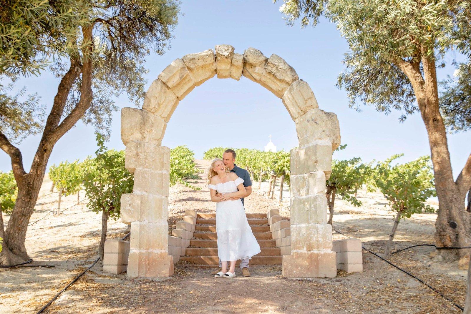 bride and groom laughing under a stone arch on Chapel Hill