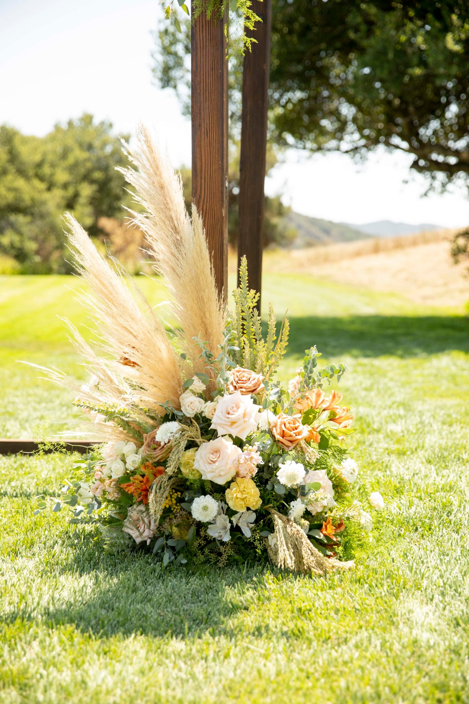 large flower arrangement with pampas grass at a wedding