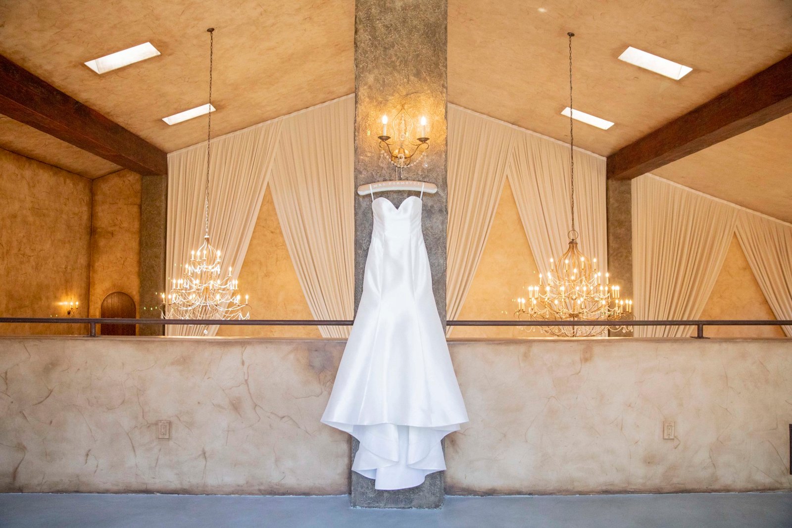 wedding dress hanging in a balcony from a wall light
