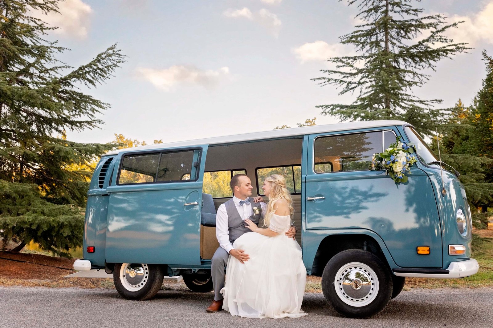 bride and groom sitting on the floor of a vw bus