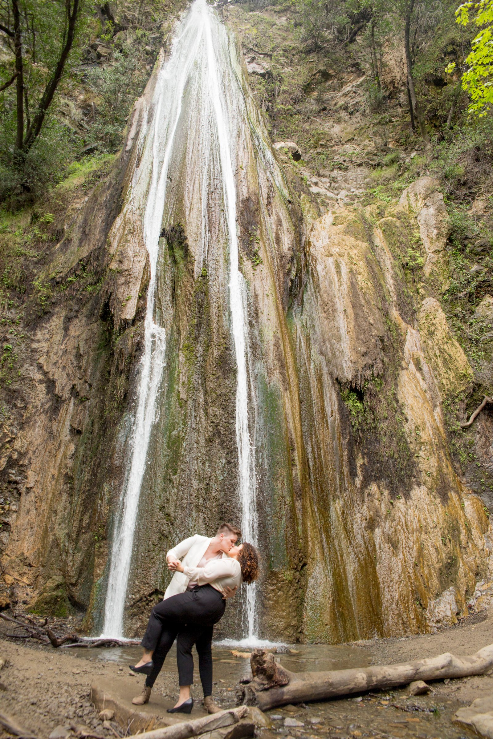 two women kiss at the waterfall at Nojoqui Falls