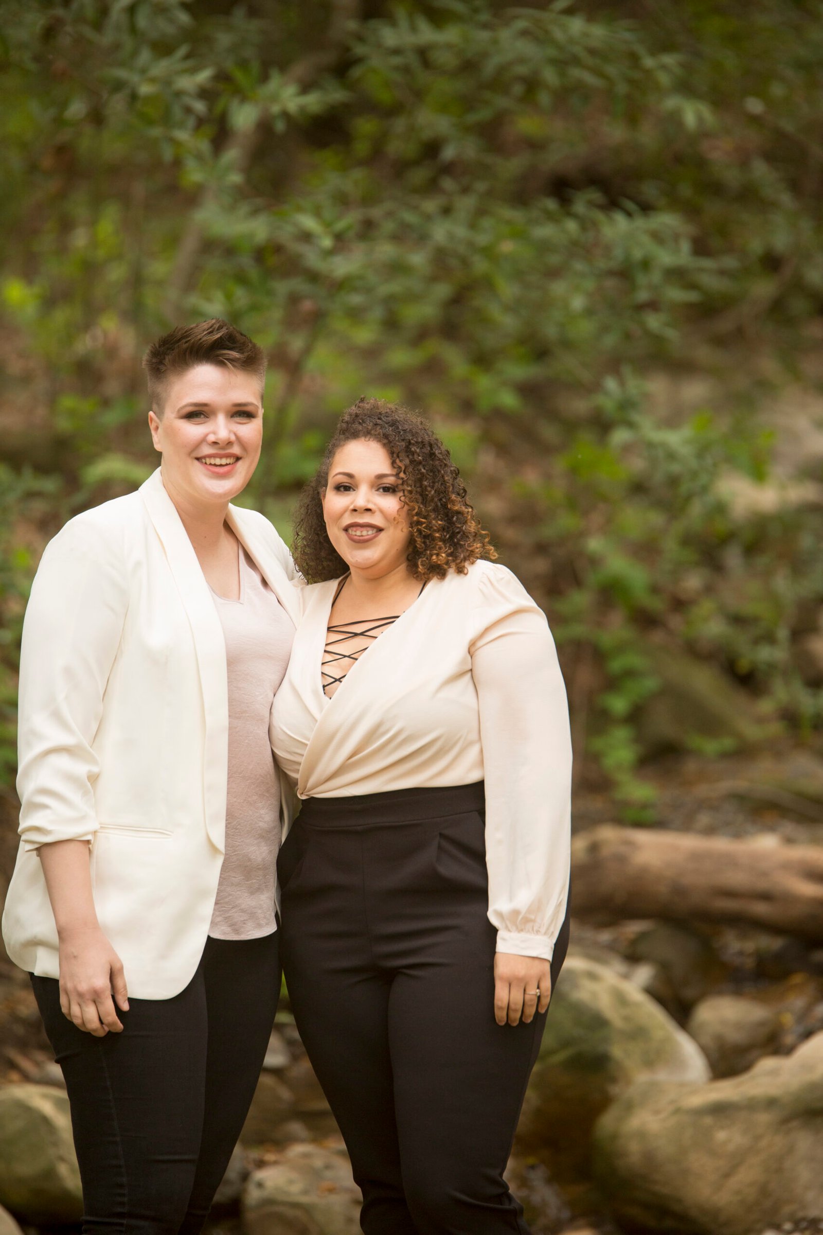 Engagement photo with two women in white shirts and black pants