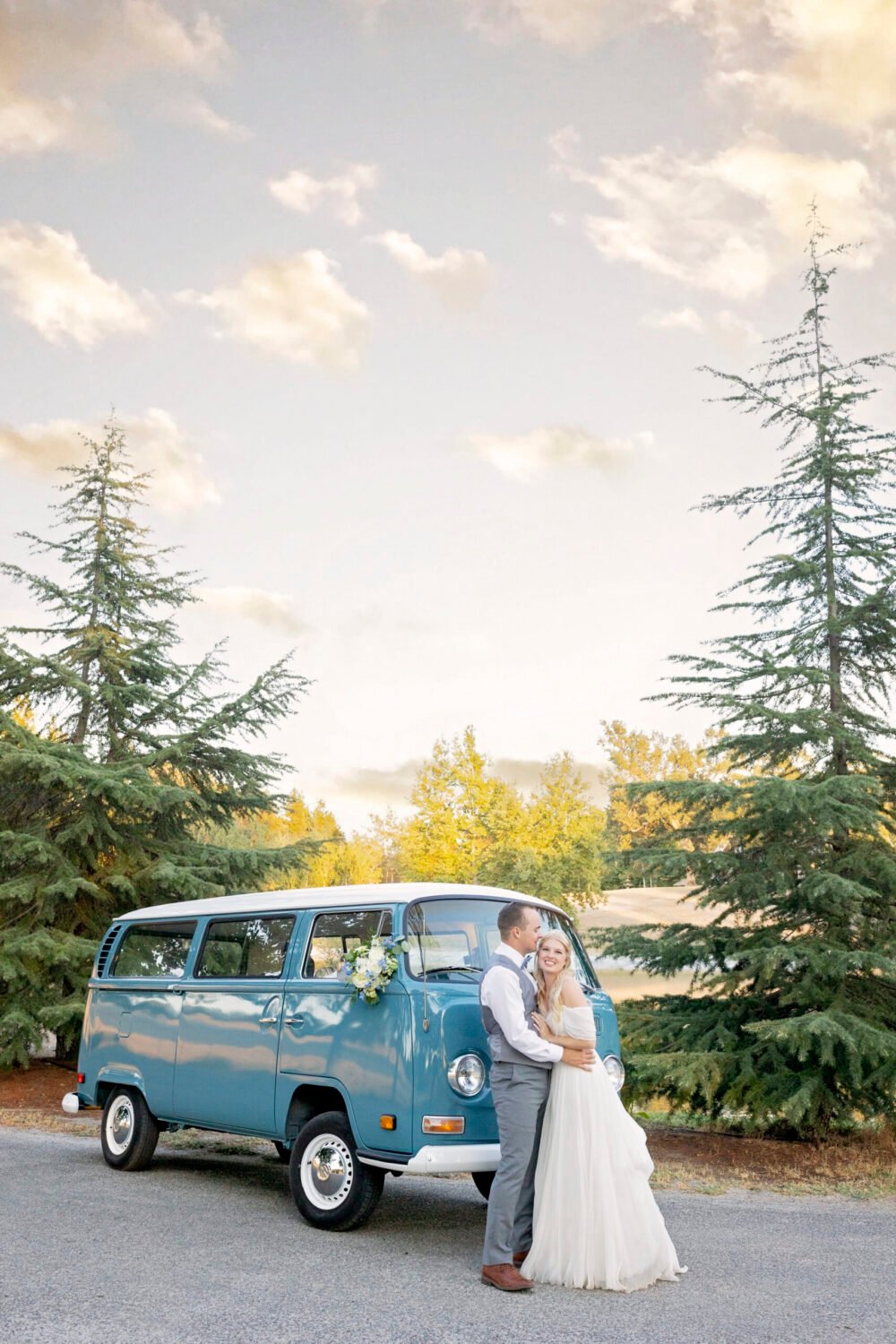 bride and groom kiss in front of a vw bus