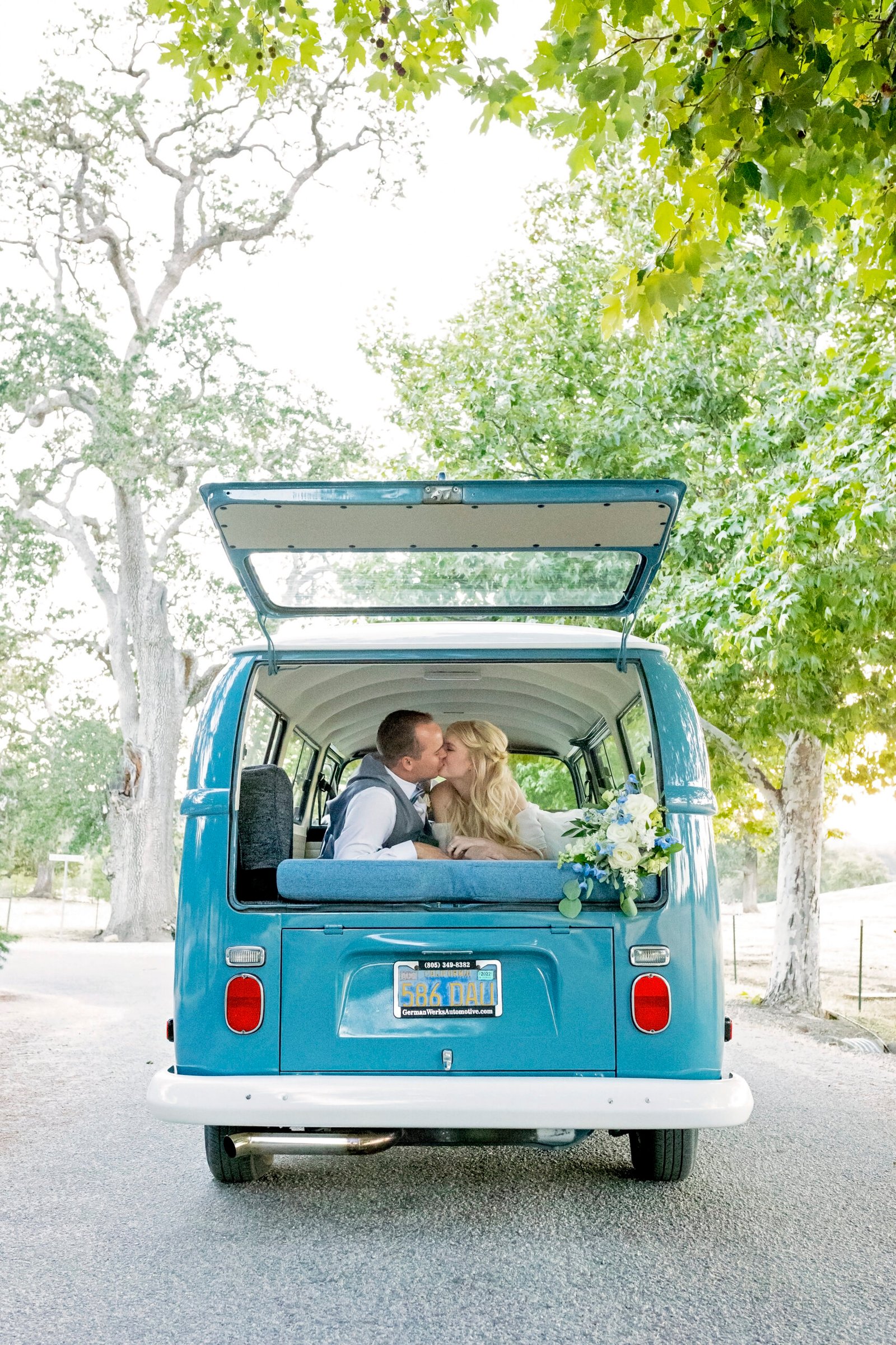 bride and groom kiss in the back of a VW bus
