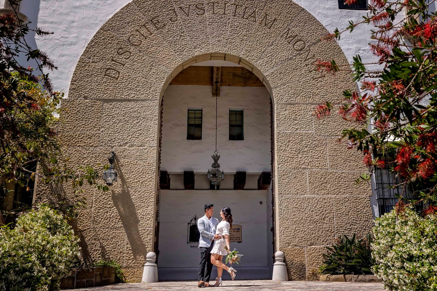 Bride and groom standing in front of an arch at the Santa Barbara Courthouse