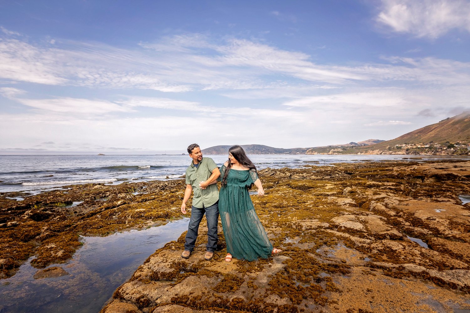 couple bumping hips during a beach engagement session