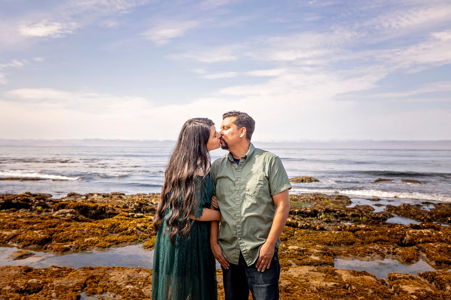 couple kissing on the beach during an engagement photo session
