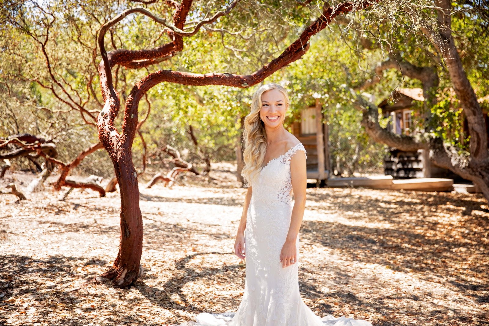 bride standing in front of a manzanita tree