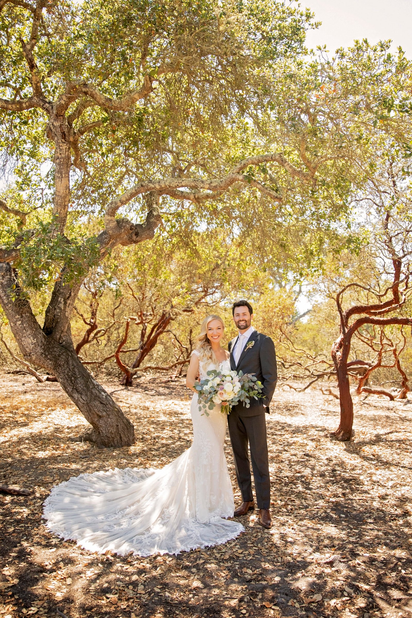 bride and groom standing together under oak and manzanita trees