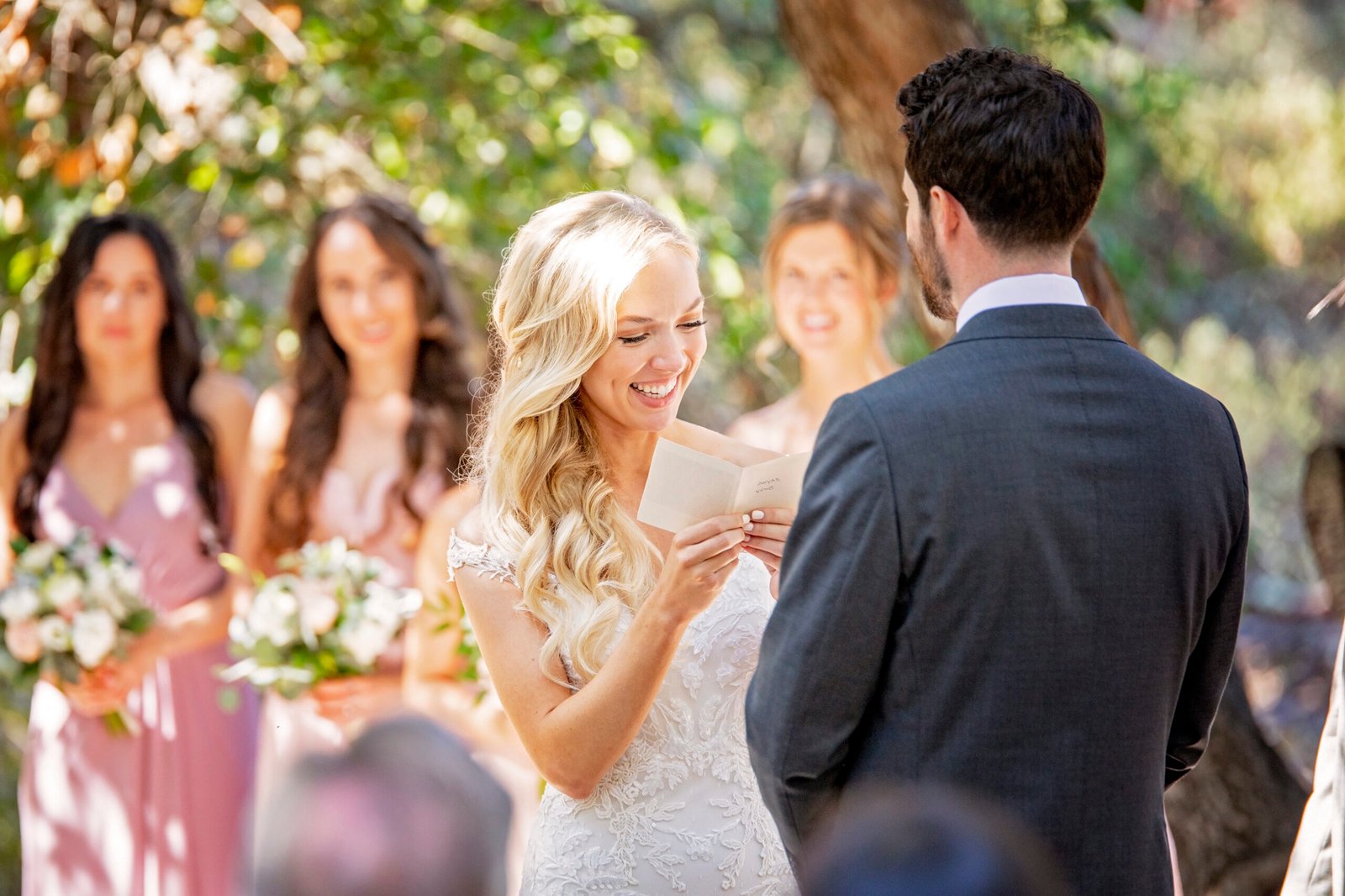 bride smiling as she reads her wedding vows