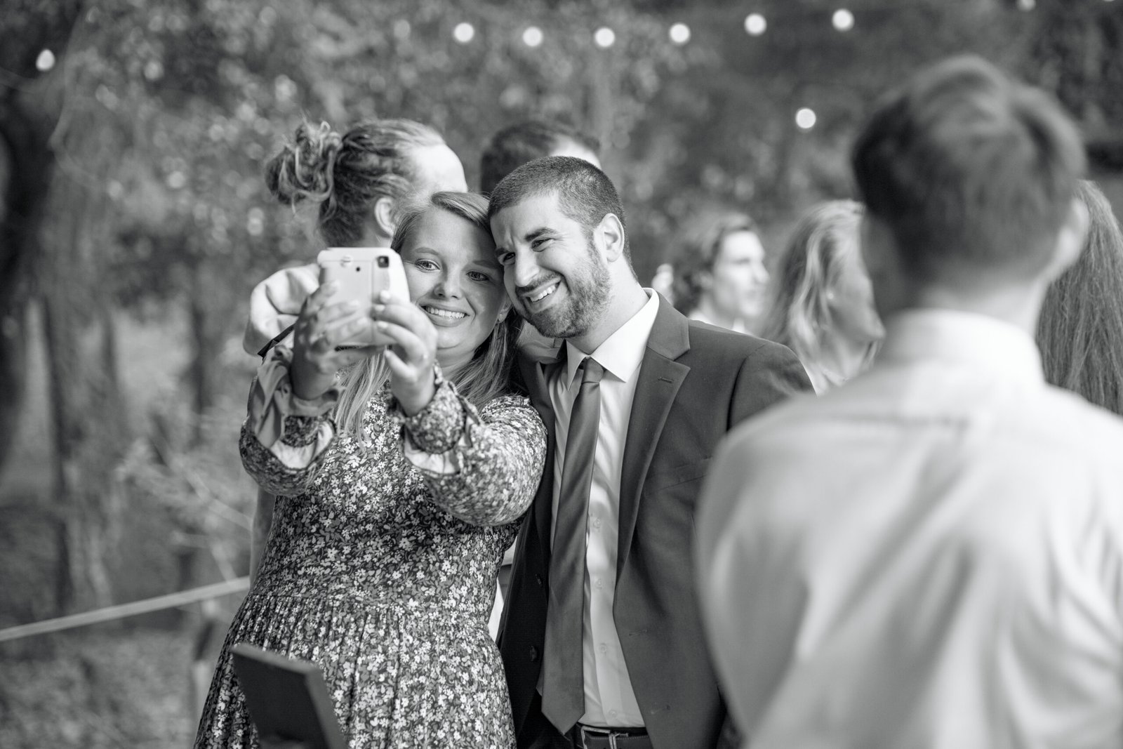 couple taking a selfie with an instant camera during a wedding reception
