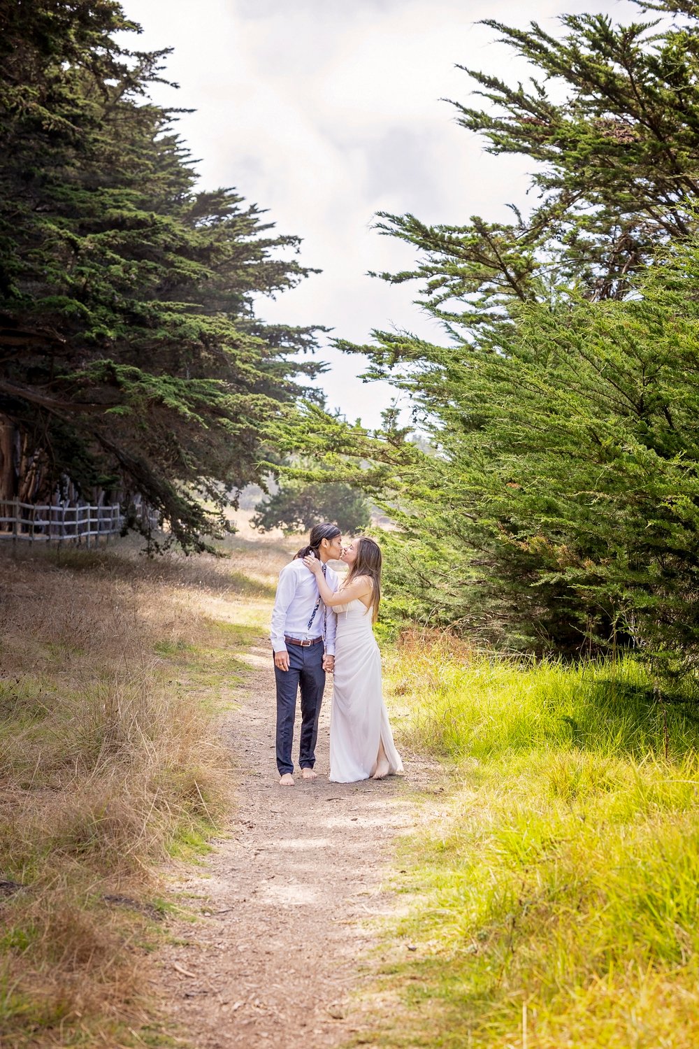 couple stopping to kiss on a dirt path