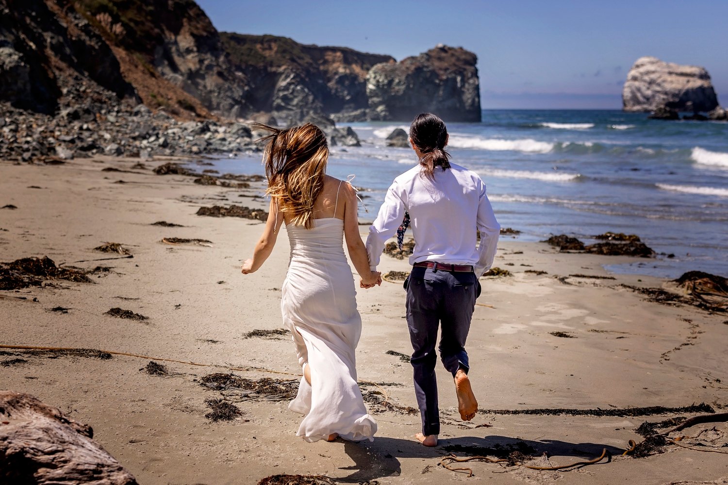 couple running toward the ocean