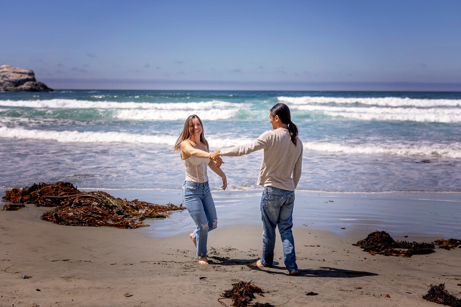 Couple dancing on the beach during an engagement session
