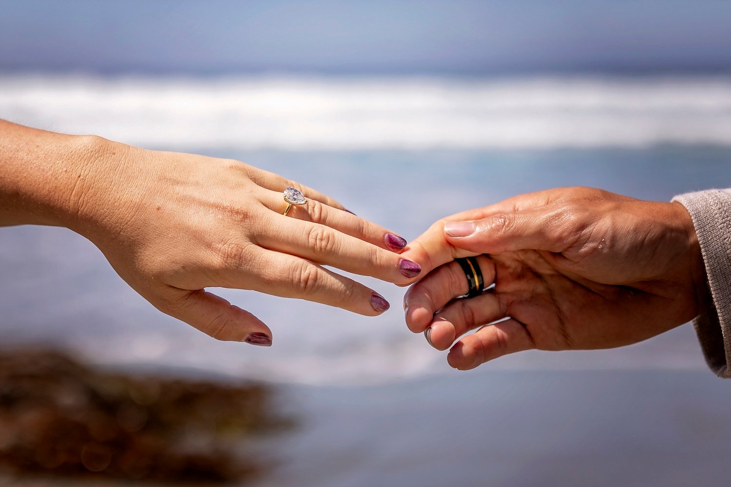 couple slowly separating hands while focused on the engagement ring