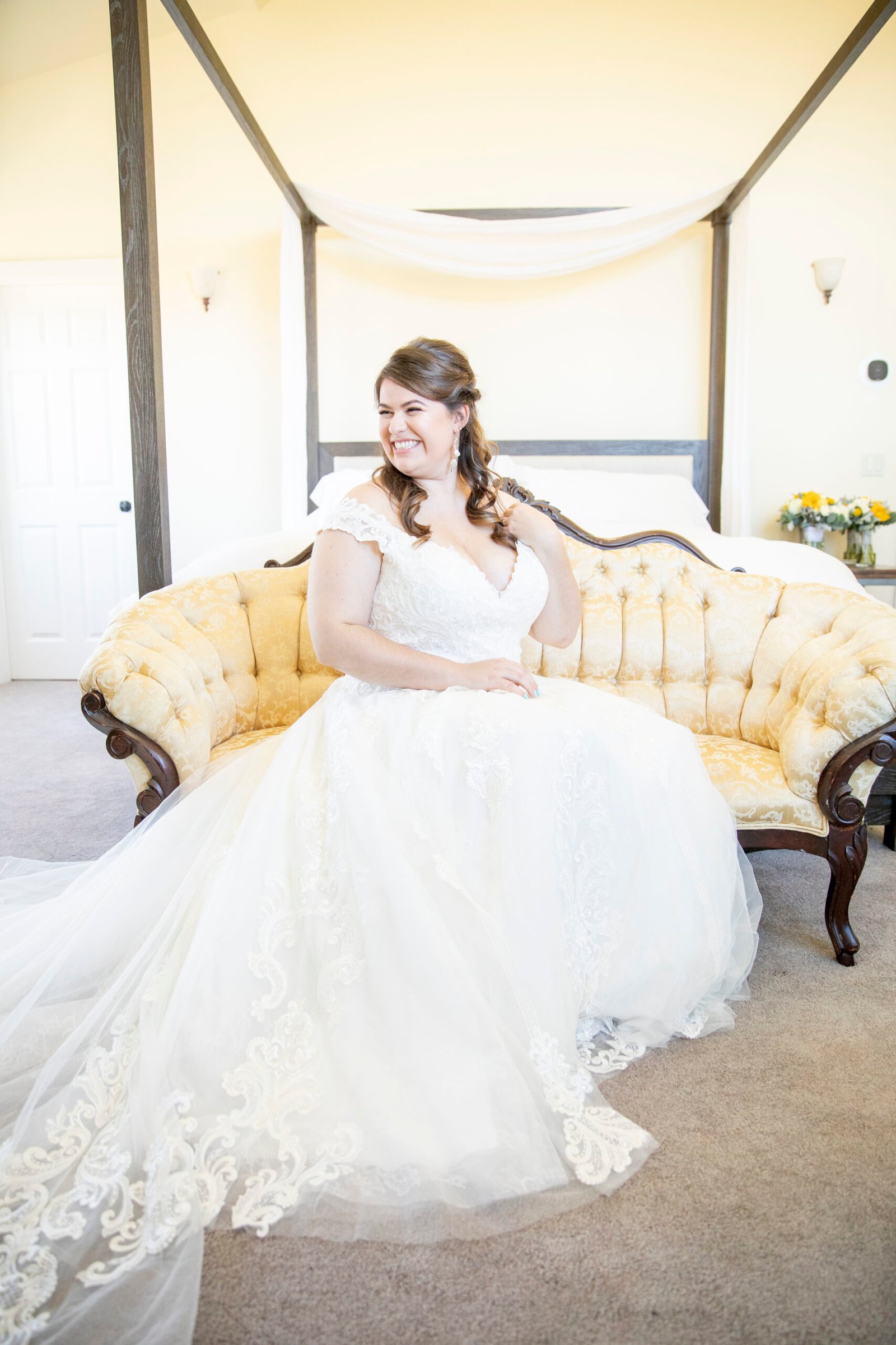 bride looking over her shoulder while sitting on an antique sofa