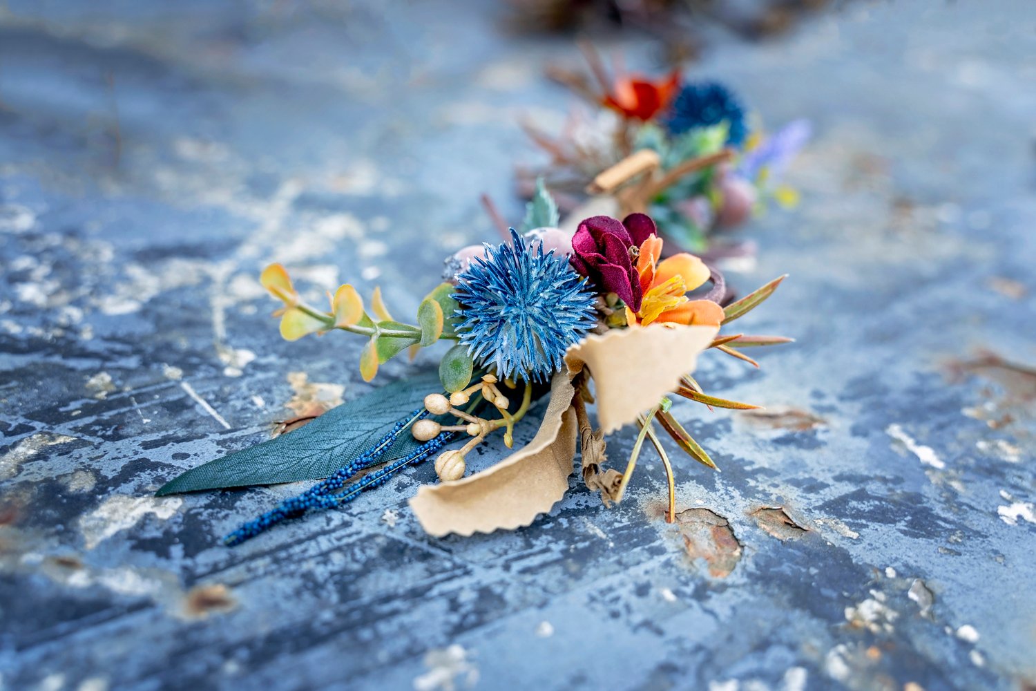 colorful boutonniere with blue, orange and red flowers