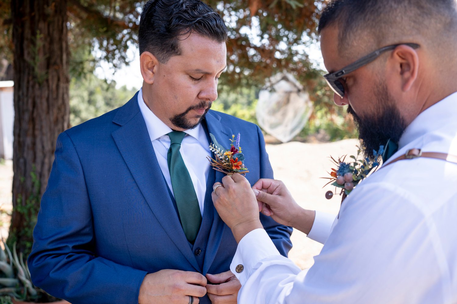 groomsman adjusting the groom's boutonniere
