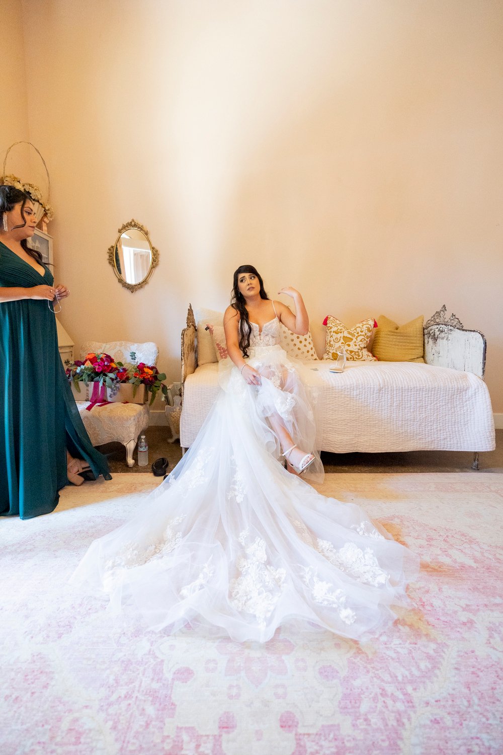 bride sitting on a bed while putting her shoes on