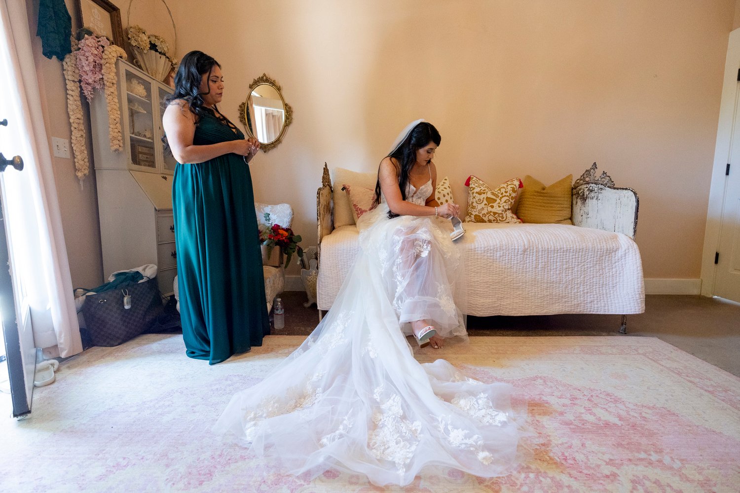 bride sitting on a day bed while putting her shoes on