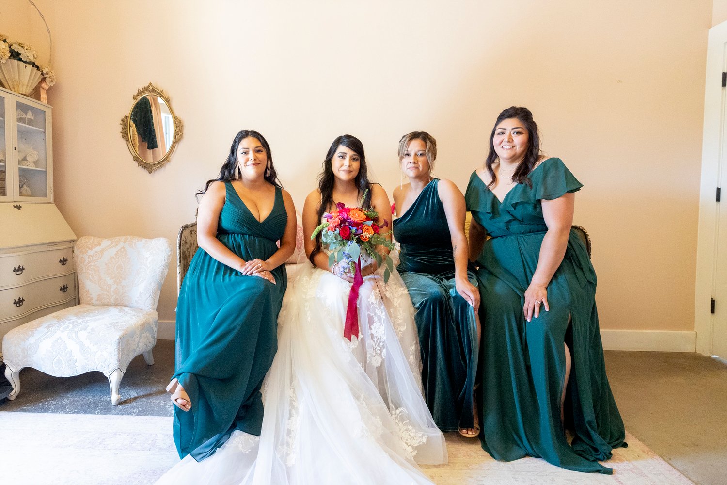 bride sitting on a bed with her bridesmaids