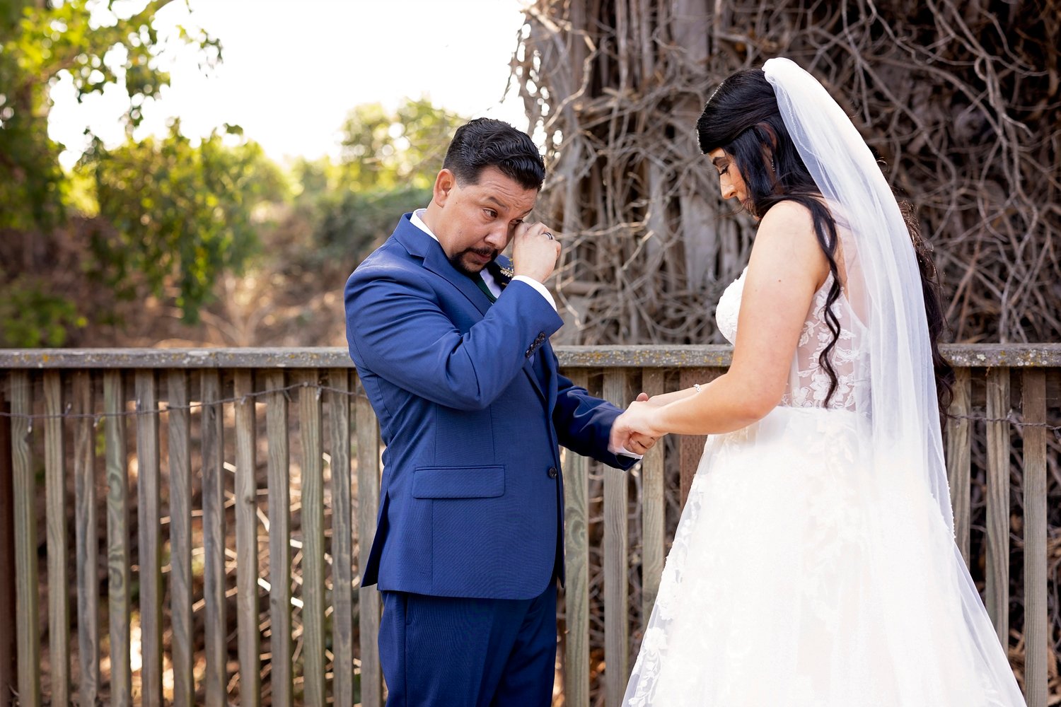 groom wiping a tear during the first look