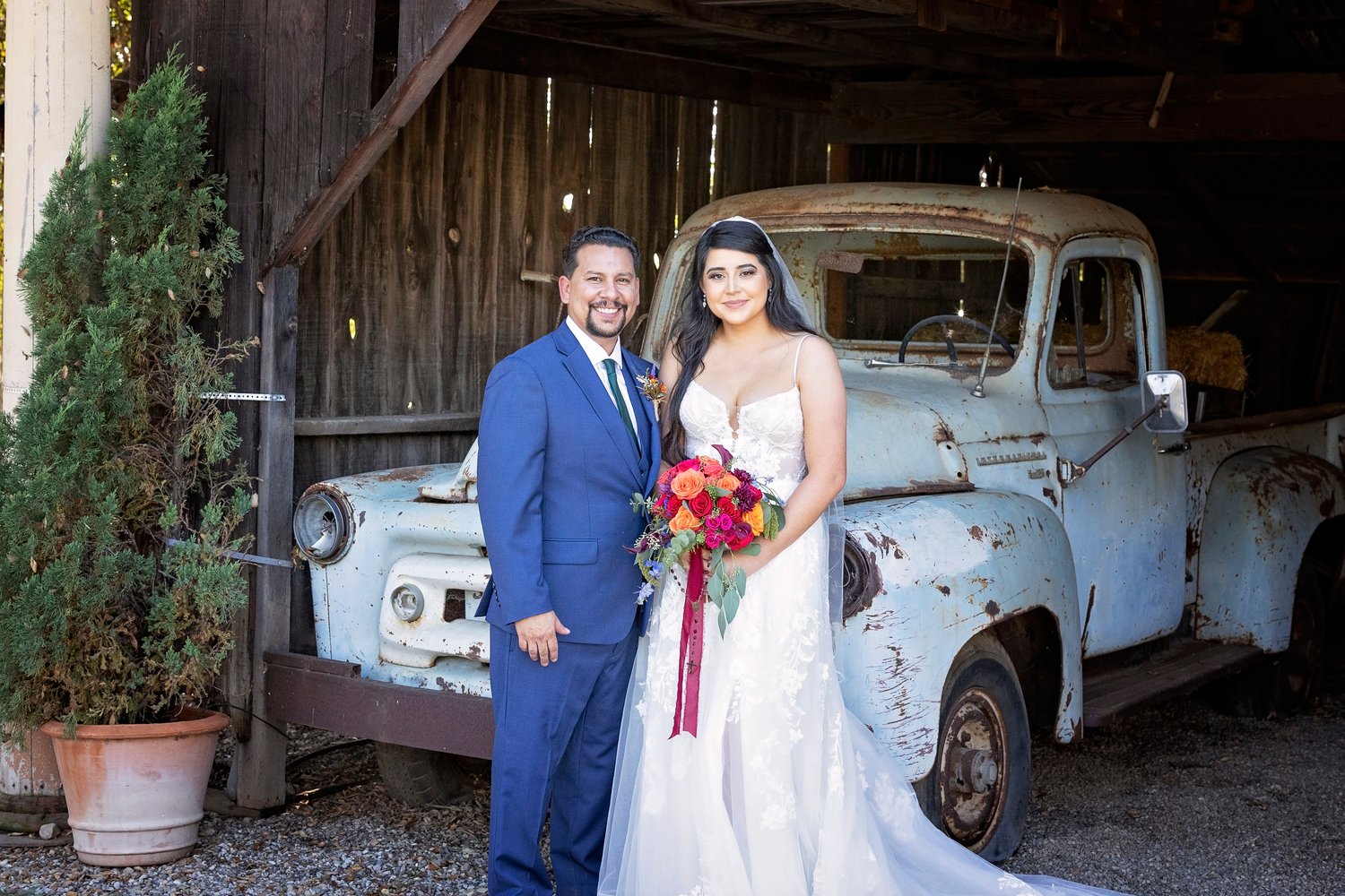 bride and groom standing in front of a vintage truck at the Dana Powers House in Nipomo