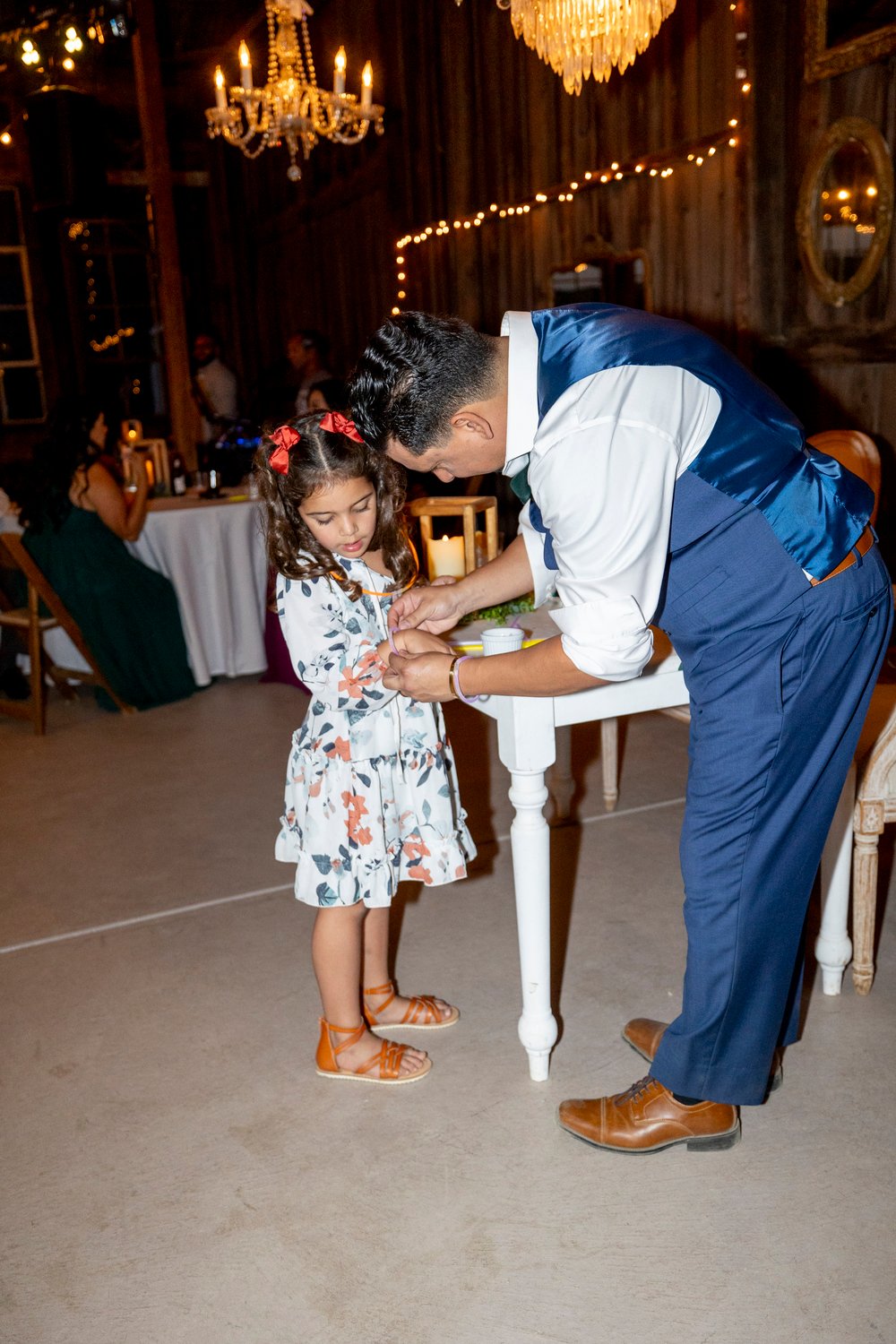 groom helping a little girl with her bracelet