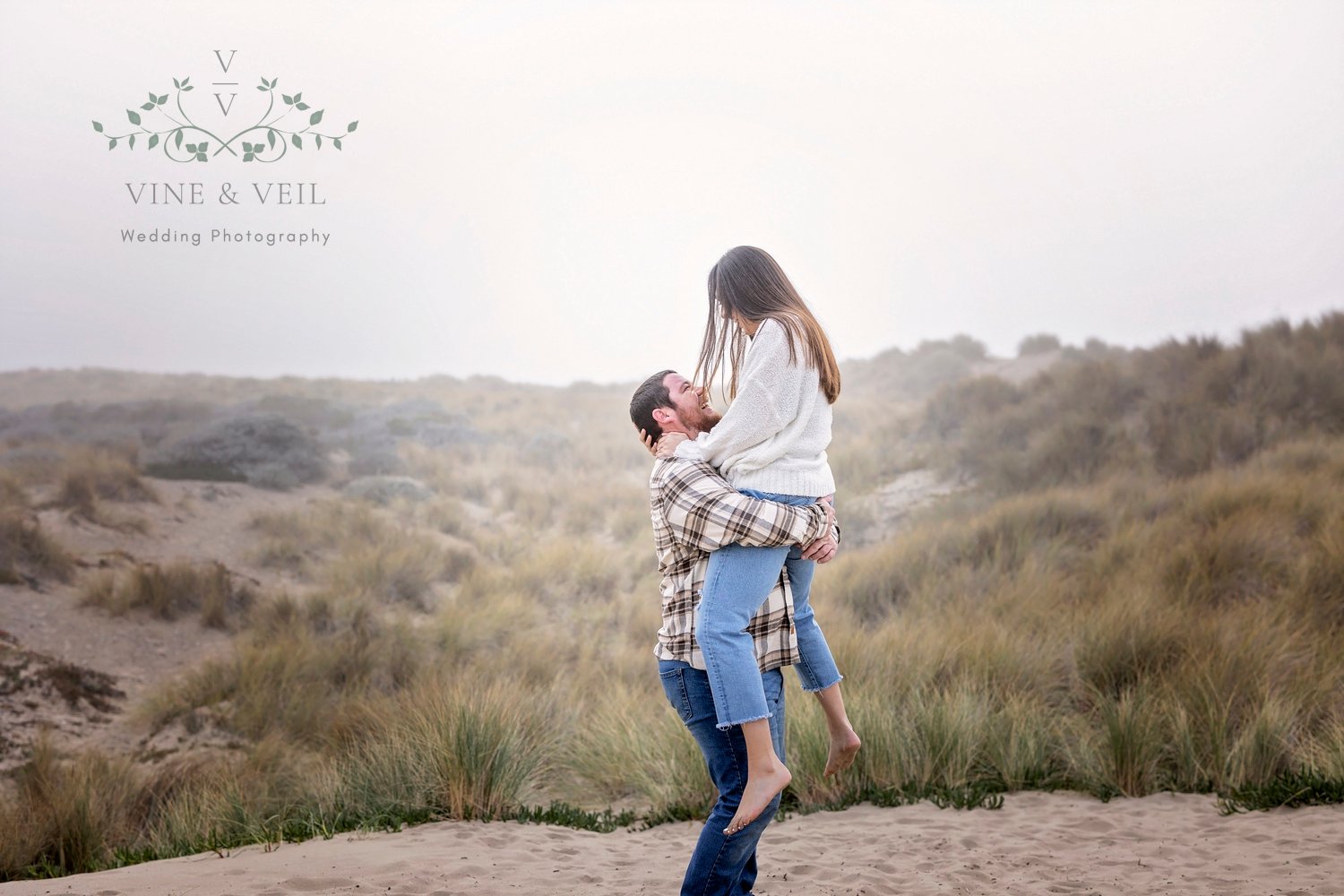 couple dancing in the sand at their engagement photoshoot