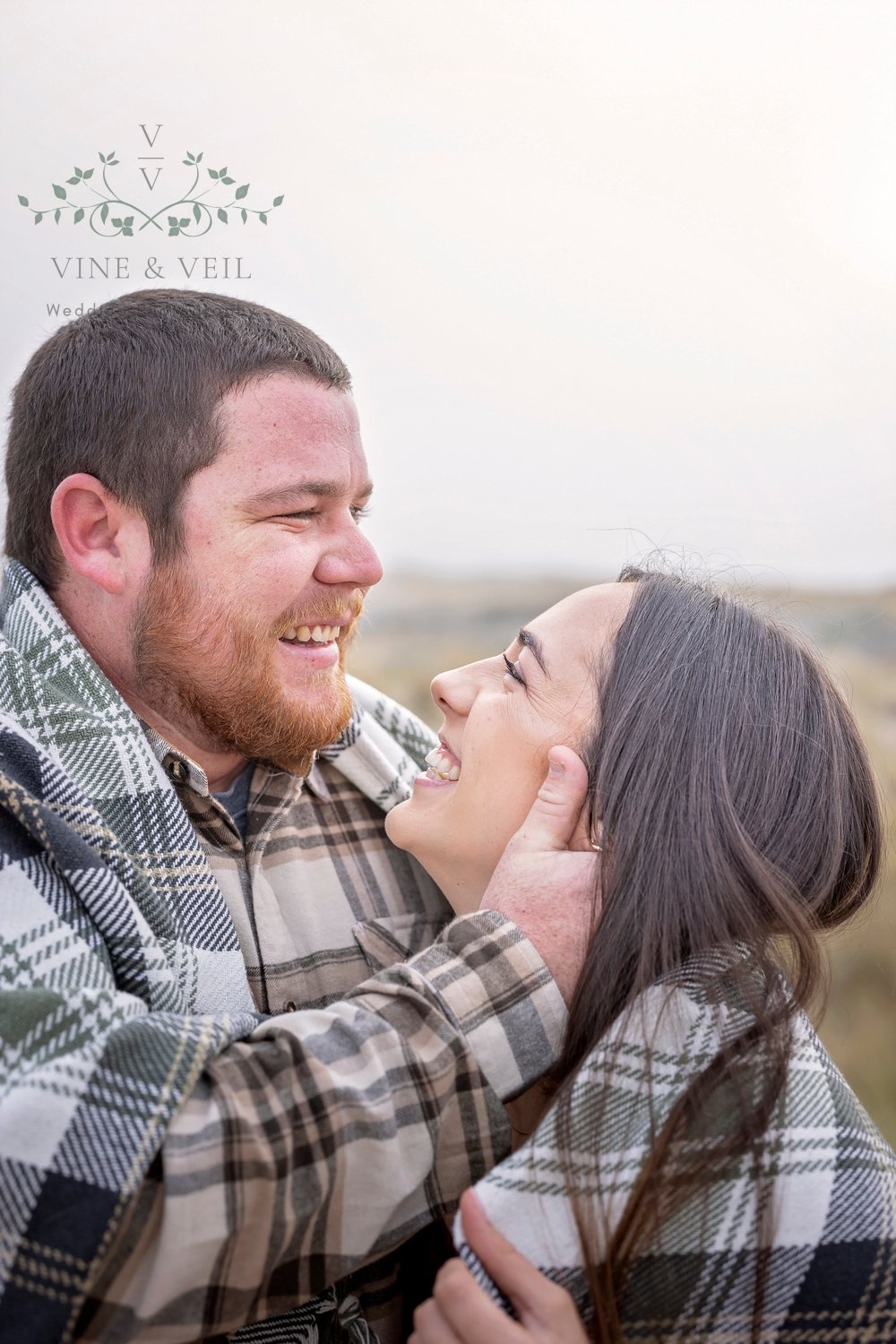 couple smiling at each other during an engagement photoshoot