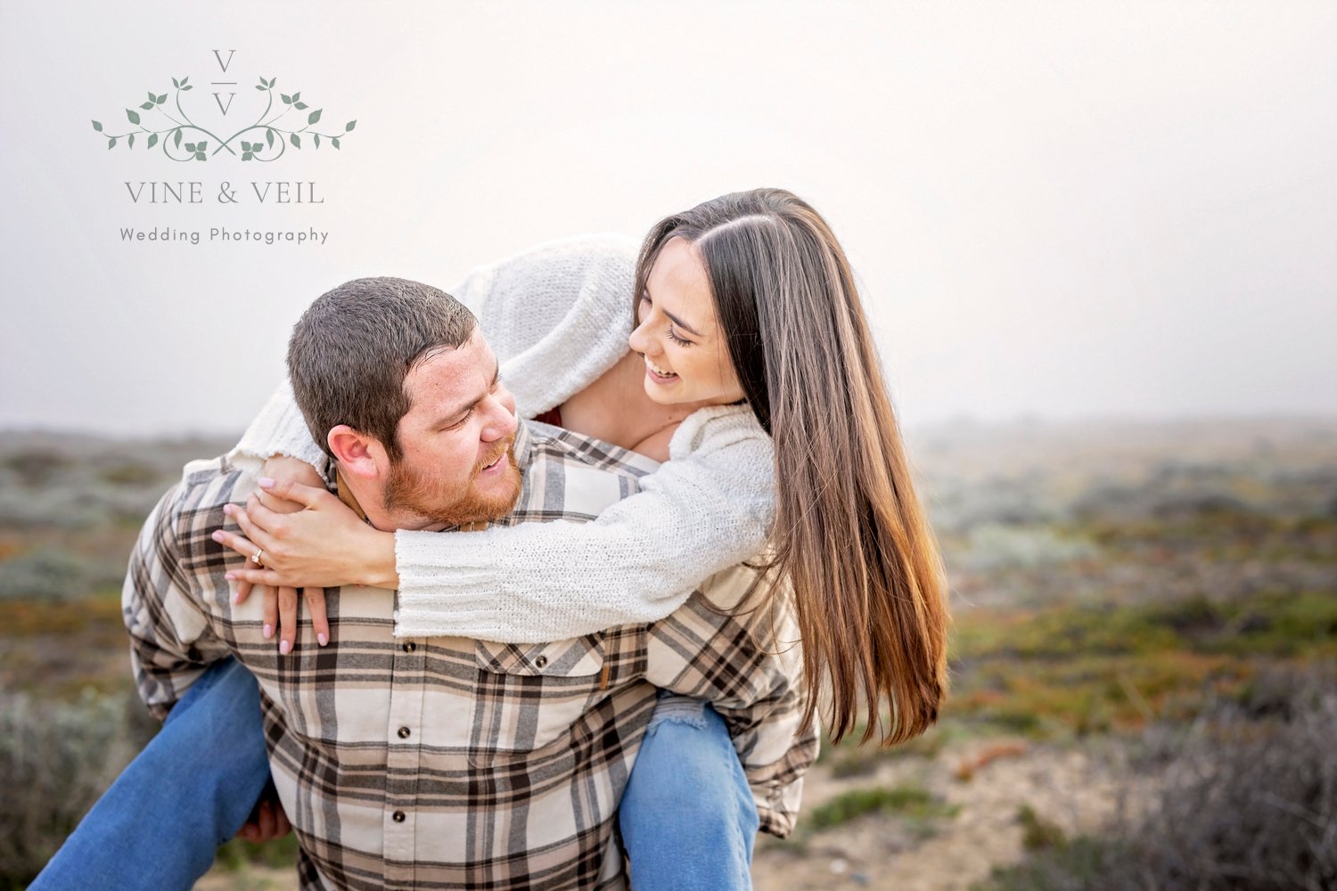 couple giving piggy back rides at the beach during an engagement photoshoot