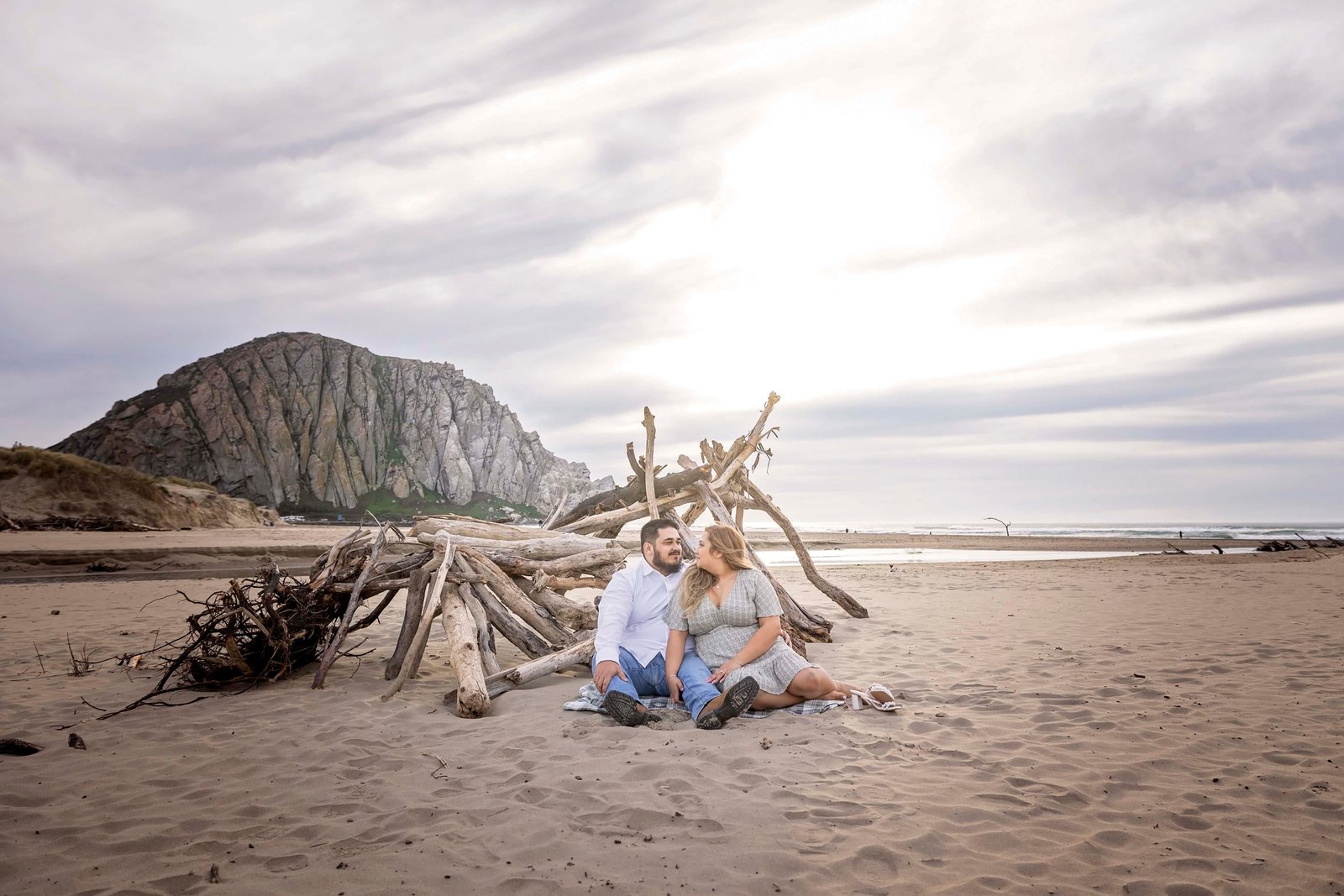 couple sitting together on the sand in Morro Bay